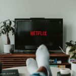 Xem phim cả nhà: phòng khách sáng sủa, một người gác chân trên sofa xem tivi